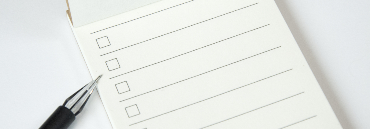 Blank to do list planner with checklist and black pen on white background, close up view